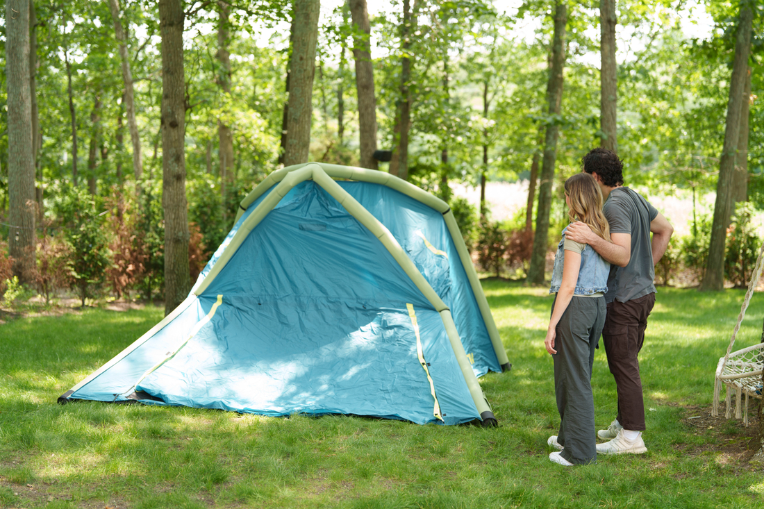 couple embracing while looking at blue and green tent
