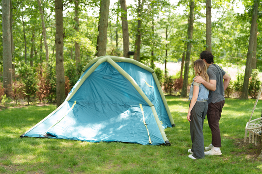couple embracing while looking at blue and green tent